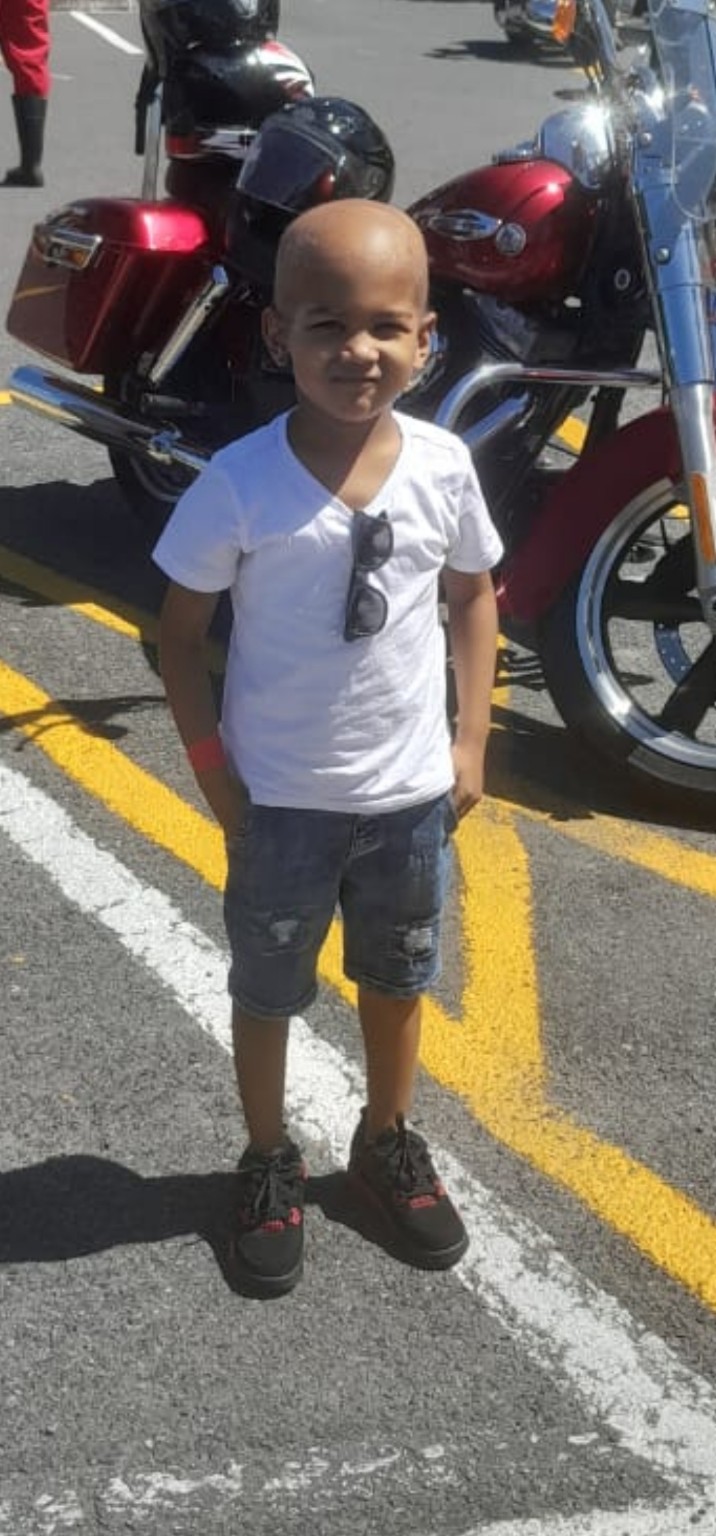 Rafeeq enjoying a day beside a motorcycle
